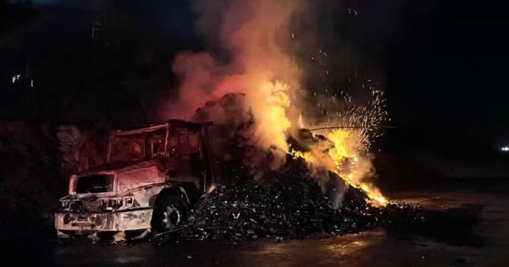 Caminhão em chamas na BR-251, em Montes Claros, com fumaça intensa enquanto equipes tentam controlar o incêndio na rodovia.